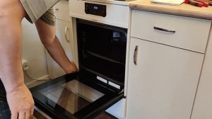 Установка дверцы духовки электроплиты Gorenje с индукционной панелью.