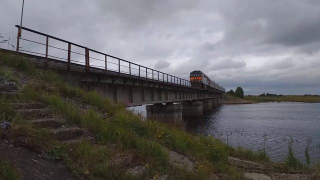 Тепловоз ТЭП-70, с пригородным поездом 6556 Ненокса-Северодвинск, проезжает мост, через реку Солза. смотреть онлайн