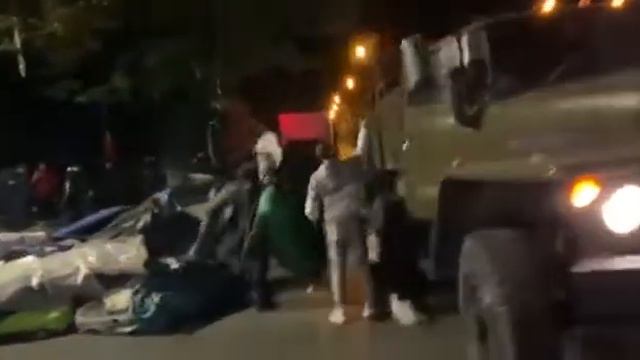 Палатки и личные вещи сгружают в транспорт , чтобы отправить на свалку. смотреть онлайн