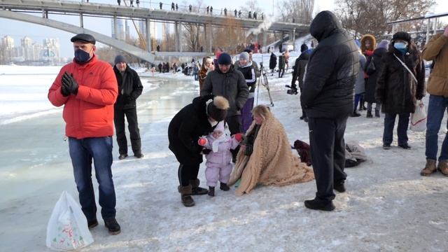Водокрещение. Девушка завернувшаяся в одеяло после купания в проруби целует свою дочку. смотреть онлайн