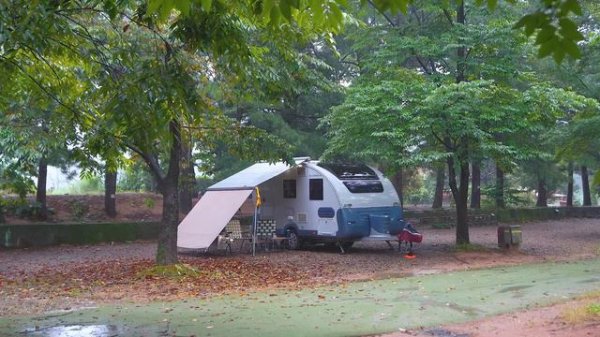 В тихом дождливом лесу уютный фургон и небольшая дровяная печка  
피치림 Peach Rim