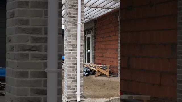 Первый этаж облицован серым кирпичом с белым швом.