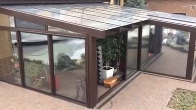 Зимний сад со стеклянной крышей и раздвижными панорамными порталами смотреть онлайн