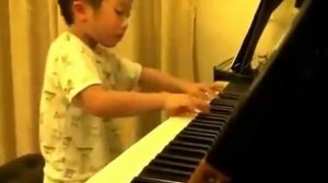 Китайский мальчик  виртуозно играет на фортепиано.