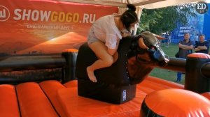 Попытка оседлать быка – девушка на аттракционе «Родео»