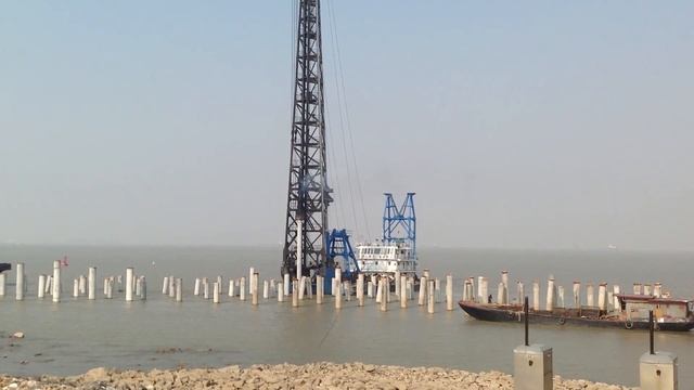 Забивка сваи оболочки дизель молотом. Сваебойная установка на палубе корабля. смотреть онлайн