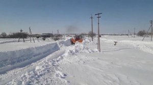Кировец чистит снег в деревне