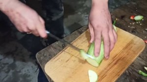 Мясо павлина с овощами в казане на костре.