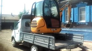 экскаватор заезжает на газель