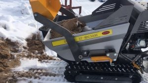 гусеничный погрузчик (думпер) грузит песок зимой