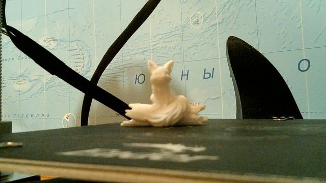 Пластиковая лисица на бревне