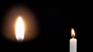 Пламя свечи и свеча горящая на черном фоне