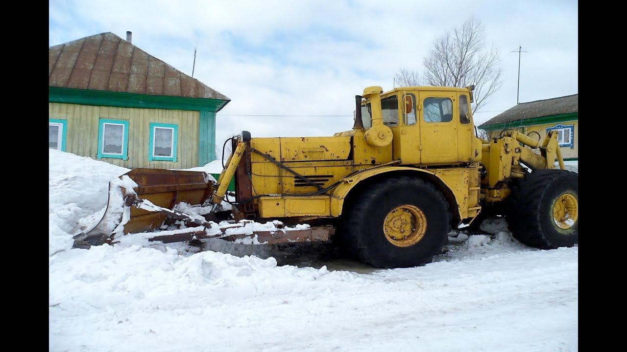 Трактор К-700 гребёт снег по улице весной смотреть онлайн