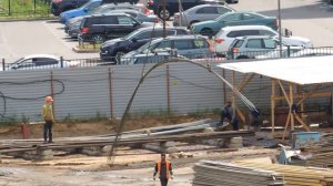 Автокран подает в котлован железные прутья (Арматура)