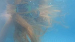 Девочка купается в бассейне