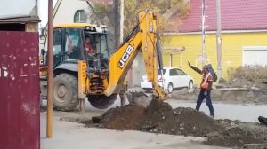 Трактор ковшом копает землю